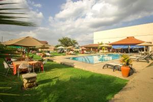 Kiserian史密斯酒店 的一个带桌椅和遮阳伞的度假游泳池