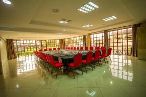 Kiserian史密斯酒店 的大型会议室,配有长桌子和红色椅子
