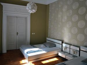 布拉格泰斯卡7号公寓式酒店的一间卧室配有一张床和一个吊灯