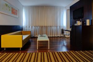 里斯本里斯本VIP Spa大酒店的客厅配有黄色的沙发和桌子