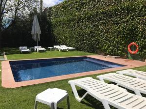利维亚Hotel Esquirol的一个带两把草坪椅和两把白色椅子的游泳池