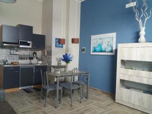 锡拉库扎Mishalay Apartment的厨房配有桌子和蓝色的墙壁