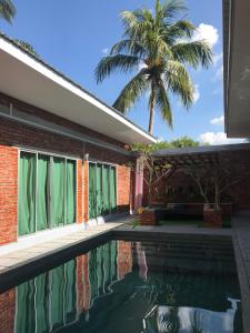 Huma丹绒鲁泳池TRV度假屋的一座带游泳池和棕榈树的房子