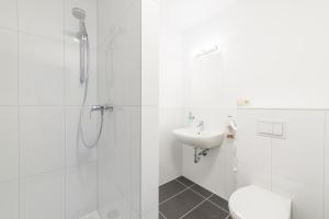 萨斯尼茨Pension Kreidefels的带淋浴和盥洗盆的白色浴室