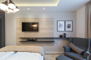 扎达尔Classy Design Accommodation的客厅配有电视、沙发和椅子