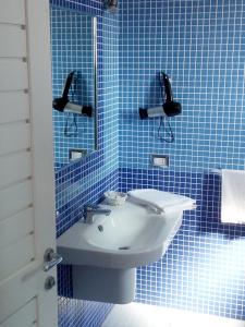 马蒂纳塔B&B Conca del Faro的蓝色瓷砖浴室设有水槽和镜子