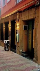 普拉森西亚林孔埃斯特雷马杜拉酒店的大楼的入口,外面设有桌子