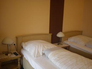 尼尔斯泰因楚库弗尔申科酒店的一间卧室设有两张床和两张带台灯的桌子。