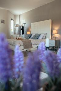 ÁriaPrivate Place Nafplio Exostis的一间卧室配有一张床和一张紫色花卉桌子