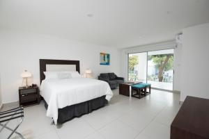 马那瓜Hotel Nicte的卧室配有床、椅子和窗户。