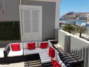 明德卢Casa Café Mindelo的阳台上配有带红色枕头的白色沙发