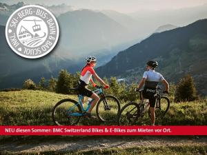 施库尔Badehotel Belvair的两人骑着自行车在山间小径上