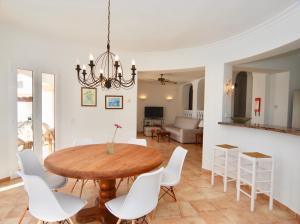 卡拉隆加Villa Sa Seni的一间带木桌和白色椅子的用餐室