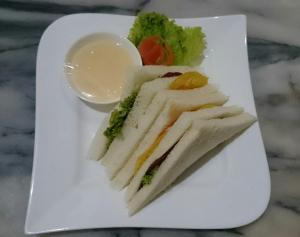 CepuGrand Cepu Hotel的上面有三明治和蔬菜的白盘