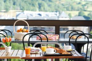 贝斯和圣阿纳斯泰斯Hotel La Gazelle的阳台上的桌子上摆着早餐食品和饮料
