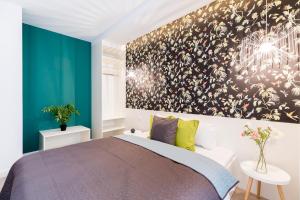 布达佩斯百老汇流浪汉公寓式酒店的卧室配有一张床,墙上挂有绘画作品