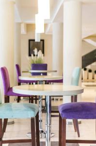 科隆科斯塔雷纳斯温泉酒店的一间用餐室,配有紫色的椅子和桌子