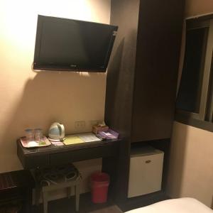 新竹棒球精致旅店的一间设有一张桌子的房间,墙上配有电视