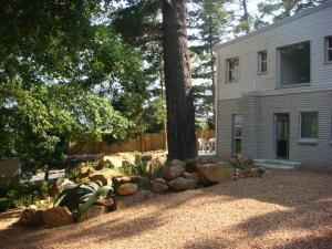 豪特湾维特乐尔斯小屋酒店的一座有房子、树和岩石的院子