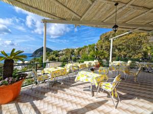 伊斯基亚弗兰茨别墅酒店​​的一个带黄色桌椅的庭院和大海