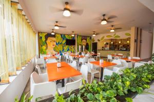 图斯特拉古铁雷斯Hotel Andiroba Palace的一间设有橙色桌子和白色椅子的餐厅