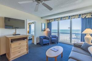 默特尔比奇Yachtsman Oceanfront Resort的带沙发和电视的客厅以及阳台。