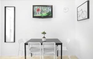 萨格勒布Maksimir-Rebro的餐桌、白色椅子和墙上的电视