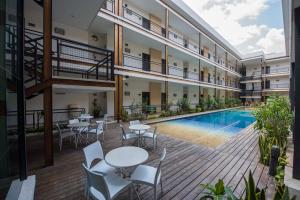图斯特拉古铁雷斯Hotel Andiroba Palace的一个带桌椅的公寓庭院和一个游泳池