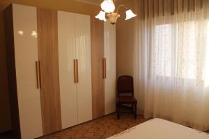 梅利萨诺Holiday Home Giovanna的卧室配有白色橱柜、椅子和窗户。