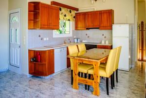 ValsamátaPanochori Apartment的厨房配有木桌和黄色椅子