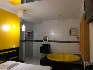 圣保罗Hotel Romance (Adults Only)的客房内的浴室设有黄色浴缸