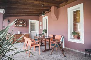达西亚Birdsing Cottage的用餐室设有粉红色的墙壁和桌椅