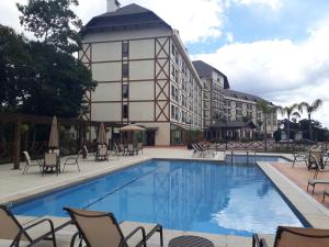 佩德拉阿祖尔Loft luxo em Pedra Azul的一座带椅子的酒店游泳池以及一座建筑