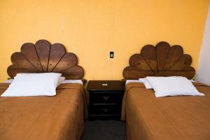 杜兰戈Hotel María Elena的两张睡床彼此相邻,位于一个房间里