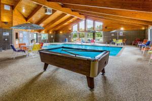 德卢斯AmericInn by Wyndham Duluth South Proctor Black Woods Event Ctr的一个带游泳池的房间中间的一张台球桌