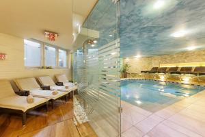 里约·迪·普斯特里亚理意其尼酒店的一个带长椅和玻璃墙的游泳池的房间