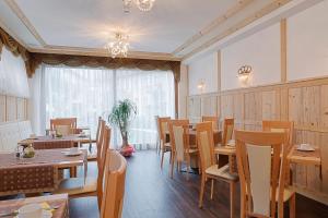 里约·迪·普斯特里亚理意其尼酒店的餐厅设有木桌、椅子和窗户