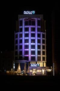 阿可贺巴Aswar Boutique Hotel的一座晚上用紫色点亮的建筑