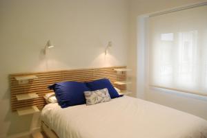瓦伦西亚威克埃尔卡门公寓的一间卧室配有一张带蓝色枕头的床和一扇窗户。