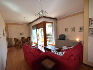 卡尼洛瑞维拉Belvilla by OYO Cannero Casa Iva的客厅配有红色的沙发和桌子