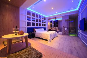 鹿港镇晨荷精品渡假旅馆 的一间卧室配有一张床、一张桌子和一台电视。