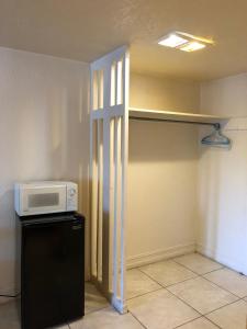 皮尔斯堡Sunset Inn- Fort Pierce, FL的厨房配有冰箱上方的微波炉