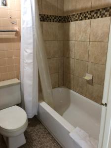 皮尔斯堡Sunset Inn- Fort Pierce, FL的浴室配有卫生间、浴缸和水槽。