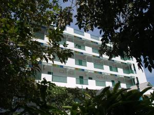 班佩罗勇府玛迈别墅酒店的前面有树木的白色公寓大楼