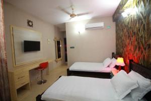 RangpurLittle Rangpur Inn的酒店客房设有两张床和一台平面电视。