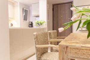 雅典Sweet Suite Flora in Vouliagmeni的厨房配有木桌和椅子