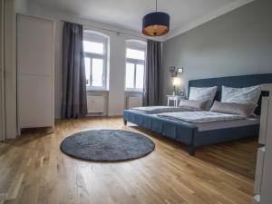 萨勒河畔瑙姆堡Stadtbleibe Naumburg的一间卧室配有蓝色的床和地毯