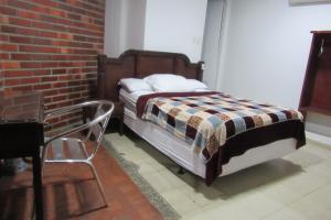 巴耶杜帕尔Hotel Nuevo Tio的一间卧室设有一张床和砖墙