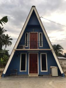 Jeram全景民宿的蓝色的房子,有尖顶,有红色的门