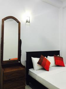 阿努拉德普勒Sunhill Lake Tourist Rest的一间卧室配有镜子和一张带枕头的床